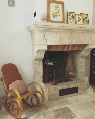 a rocking chair sitting in front of a fireplace at Gîte Maison Necty in Auvillar