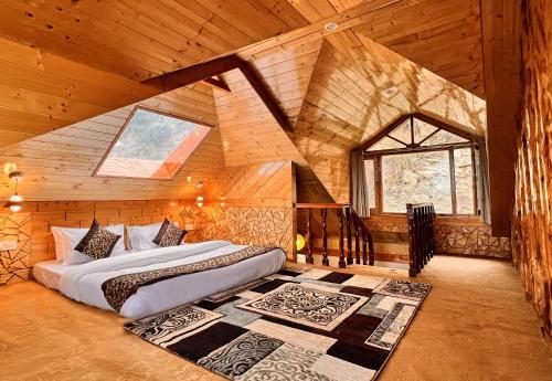 a bedroom with a bed in a wooden house at Jomotel Talai in Cheog