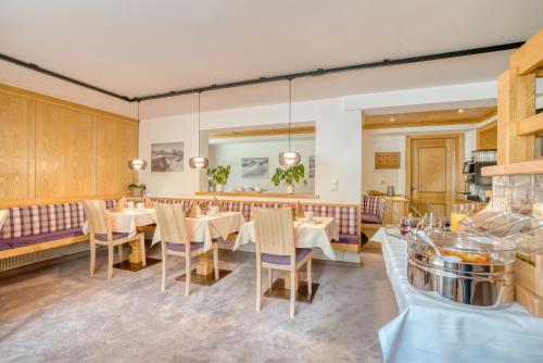 uma sala de jantar com mesas e cadeiras brancas em Landhaus Maria em Stuben am Arlberg