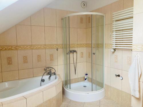 La salle de bains est pourvue d'une baignoire et d'une douche. dans l'établissement Hostel Dalia, à Zielona Góra