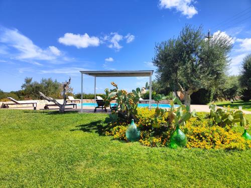 a garden with flowers and a pavilion in a park at Villa Mest Pepp in Monopoli