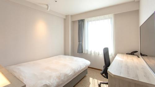 a bedroom with a bed and a desk and a window at Kissuien Stay&Food in Kyotango