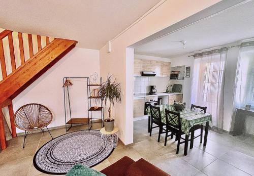 a kitchen and dining room with a table and chairs at Maison 2 Chambres - TV - CLIM - BABY FOOT in Ruelle-sur-Touvre