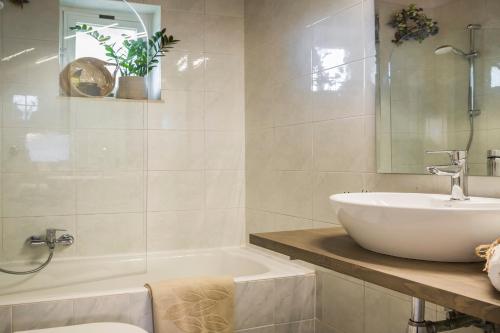 a bathroom with a white tub and a sink at Malibu Superior Apartment in Argostoli