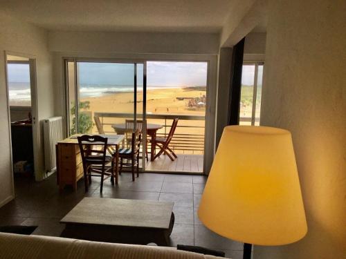 sala de estar con vistas a una mesa y sillas en Anglet sables d'or - vue océan, en Anglet