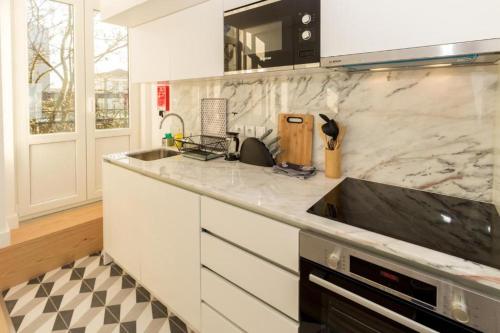 a kitchen with a sink and a counter top at Oporto Modern Apartments - Campanha Train Station in Porto