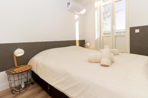 a bedroom with a bed with white sheets and a window at Oporto Modern Apartments - Campanha Train Station in Porto