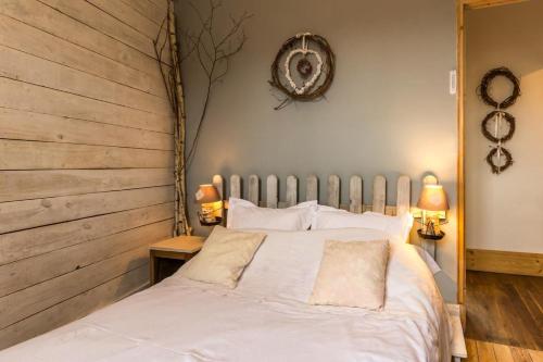 1 dormitorio con 1 cama blanca y 2 lámparas en La Palette Fleurie, en Laignes