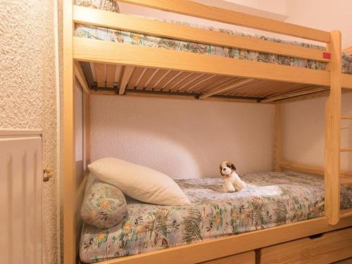 a small dog sitting on the bottom bunk of a bunk bed at Appartement Saint-Chaffrey , 1 pièce, 4 personnes - FR-1-330E-95 in Saint-Chaffrey
