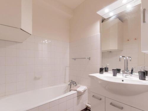 a white bathroom with a tub and a sink at Appartement Saint-Chaffrey , 1 pièce, 4 personnes - FR-1-330E-95 in Saint-Chaffrey