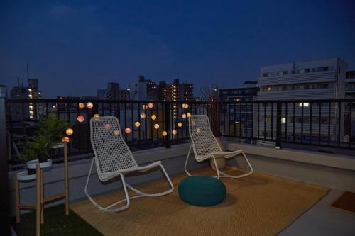 two chairs on a balcony with a view of the city at Asakusa New City Hotel in Tokyo