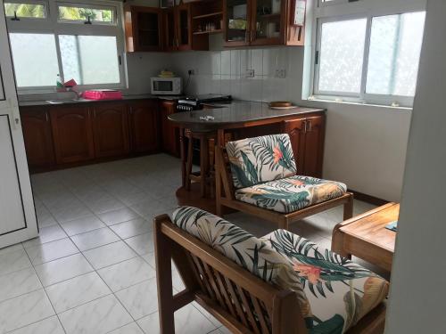 a kitchen with two chairs and a table at Royale Self Catering Apartments in Anse Royale
