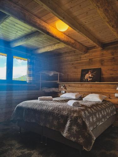 a bedroom with a large bed in a wooden room at Domek Na Wypasie in Jugów
