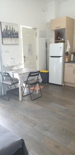 a kitchen with a table and two chairs and a refrigerator at Bonito Apto Barrio del Pilar Smart Fit in Madrid