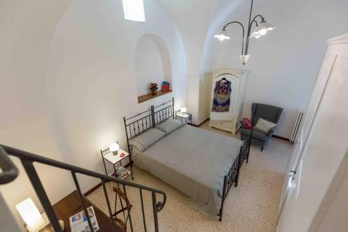 Un dormitorio con una cama y una silla en una habitación. en Da Concavo e Convesso, en Locorotondo