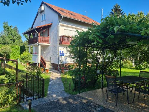 a house with a table and chairs in a yard at Apartment Garden in Slunj