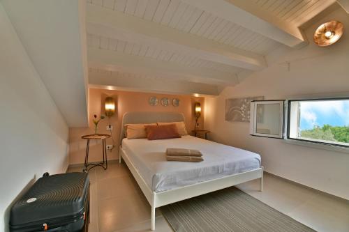 um quarto com uma cama branca e uma janela em Villa Nausica pool view on the sea wifi free perfect for big group em Ragusa