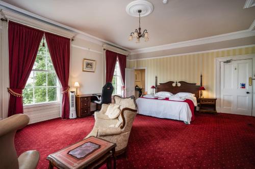 a bedroom with a bed and a couch and a chair at St Nicholas House in Spalding