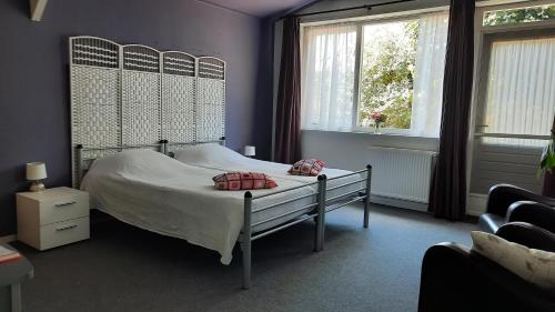 a bedroom with a bed and two windows at Vakantiewoning De Berkeboom in Winterswijk