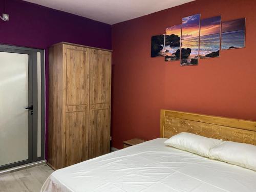 a bedroom with a bed and two paintings on the wall at City Apartments in Port Louis