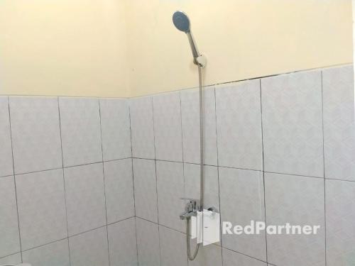 a shower with a shower head in a bathroom at Navisha Guest House Syariah near Exit Tol Batang RedPartner in Pekalongan