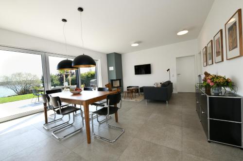 a dining room and living room with a table and chairs at Seehaus Mühlfeld in Löbnitz