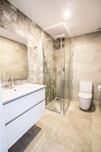 La salle de bains est pourvue d'un lavabo, de toilettes et d'une douche. dans l'établissement 4-2 Apartamento de diseño en el centro de Reus, à Reus