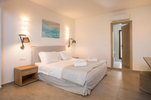 a bedroom with a bed with two towels on it at Terra Pietra Luxury Villas & Suites in Lardos