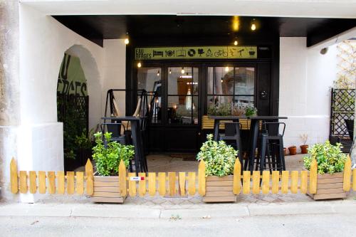 a restaurant with potted plants in front of a building at Eau Berges in Vicdessos