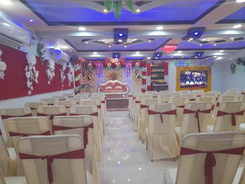 a hall with rows of chairs and a stage at Hotel G M FORUM in Kānpur