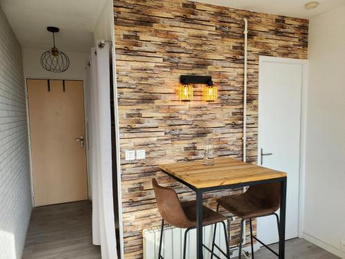 d'une salle à manger avec une table en bois et un mur en pierre. dans l'établissement Studio avec balcon, vue sur jardins et cathédrale, à Albi