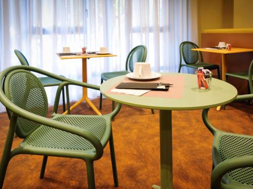 une table et des chaises avec un chapeau en haut dans l'établissement Mercure Perpignan Centre, à Perpignan