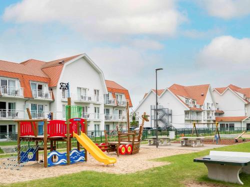 - une aire de jeux avec un toboggan et des équipements de jeux dans un parc dans l'établissement ibis Styles Nieuwpoort, à Nieuport