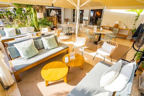 a living room with couches and a table and chairs at Hostal la Savina in La Savina