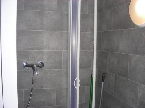 a shower with a shower head in a bathroom at Kleine FEWO zentral gelegen in Künzell