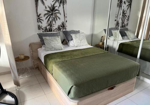 1 dormitorio con 1 cama con edredón verde en Centre de Juan les pins 100m plages Easy Check-in en Juan-les-Pins