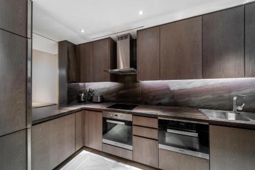 a kitchen with stainless steel appliances and wood cabinets at Five Palm Jumeirah Dubai in Dubai
