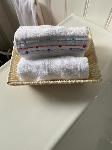 twee handdoeken zitten op een mand op een wastafel bij Cedar Cottage in Warrenpoint