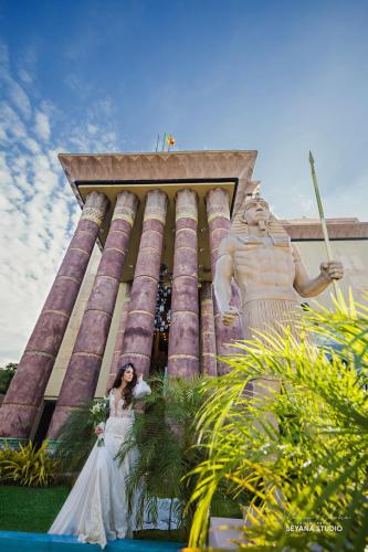 a bride standing in front of a statue at Hotel Royal Ramesses - Katunayake in Seeduwa