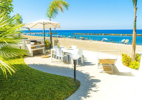 eine Terrasse mit Tisch und Stühlen sowie Strand in der Unterkunft Villa di Lusso sul Mare a Diamante - Villa Ventre in Belvedere Marittimo
