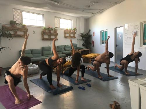 un grupo de personas haciendo yoga en una sala de estar en Medano Nest Hostel, en El Médano
