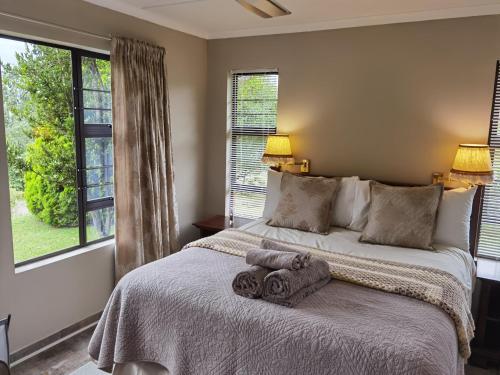 1 dormitorio con 1 cama con 2 toallas en Misty peaks Cloudlands, en Bergview