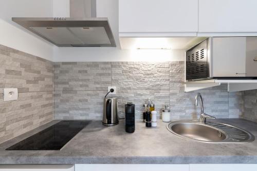 a kitchen counter top with a sink and a sink at Appartement 2 pièces au calme proche Martinez avec parking privé in Cannes