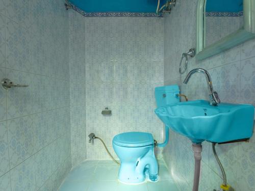 a bathroom with a blue toilet and a sink at The Maurvi Inn in Jaipur