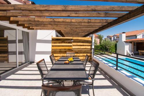 d'une table et de chaises sur un balcon avec piscine. dans l'établissement Apartments Luka i Toni, à Vodice