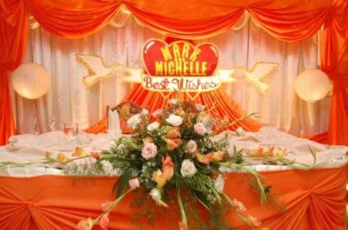 a table with flowers and a sign for a mardi gras at Demiren Hotel in Cagayan de Oro