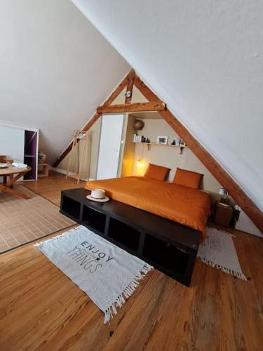 une chambre avec un lit dans un grenier dans l'établissement logement avec jardin de bord Mer PORT NAVALO, à Arzon