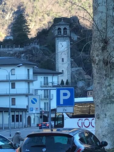 a car parked in front of a building with a clock tower at bb chiavenna centro storico in Chiavenna