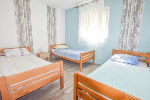 a bedroom with two beds and a window at House Romano in Neviđane