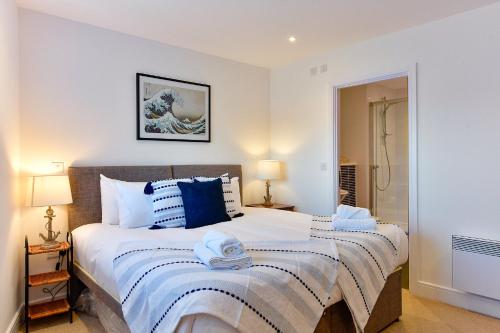 a bedroom with a large bed with blue and white pillows at Just Stay Wales - Meridian Tower Marina & City View - 2 Bed Apartment in Swansea